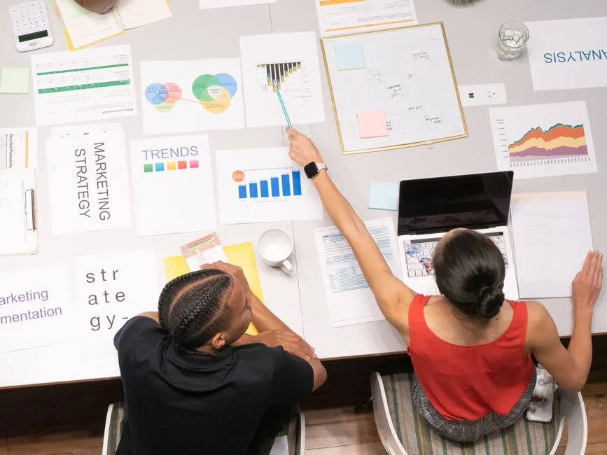 A creative mood board with business touchpoints and inspirational images taped to a white wall.